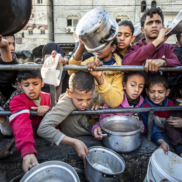 Des enfants se pressent pour obtenir de la nourriture lors d'une distribution à Rafah, dans la bande de Gaza, le 12 mars 2024. (JEHAD ALSHRAFI / ANADOLU / AFP)