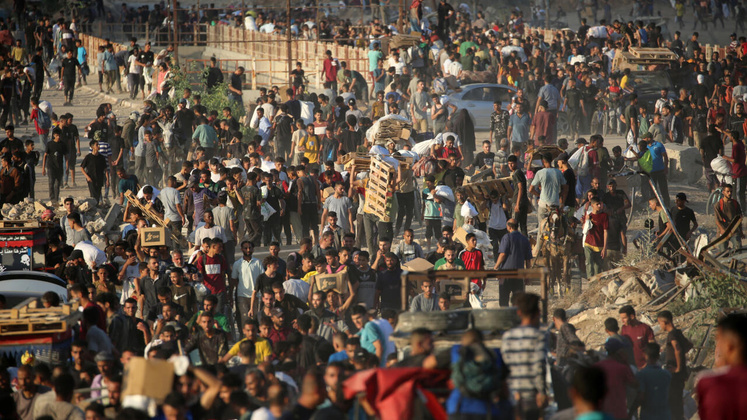 Des Palestiniens se rassemblent à un point de distribution d'aide mis en place par la Fondation humanitaire de Gaza (GHF), près du camp de réfugiés de Nuseirat, dans le centre de la bande de Gaza, le 25 juin 2025. © Eyad Baba, AFP