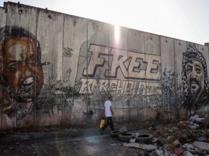 Les portraits de Marwan Barghouti (à gauche), membre éminent du Fatah et détenu palestinien le plus en vue en prison depuis un quart de siècle, et du défunt leader palestinien Yasser Arafat (à droite), qui ornent une partie du mur de séparation controversé d'Israël près du poste de contrôle de Qalandiya, entre Jérusalem et Ramallah, le 22 septembre 2025. (Photo de Zain JAAFAR / AFP)