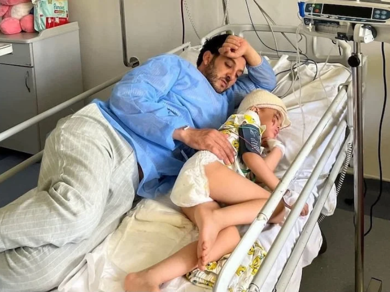 La petite Ghita dans les bras de son père lors de son hospitalisation