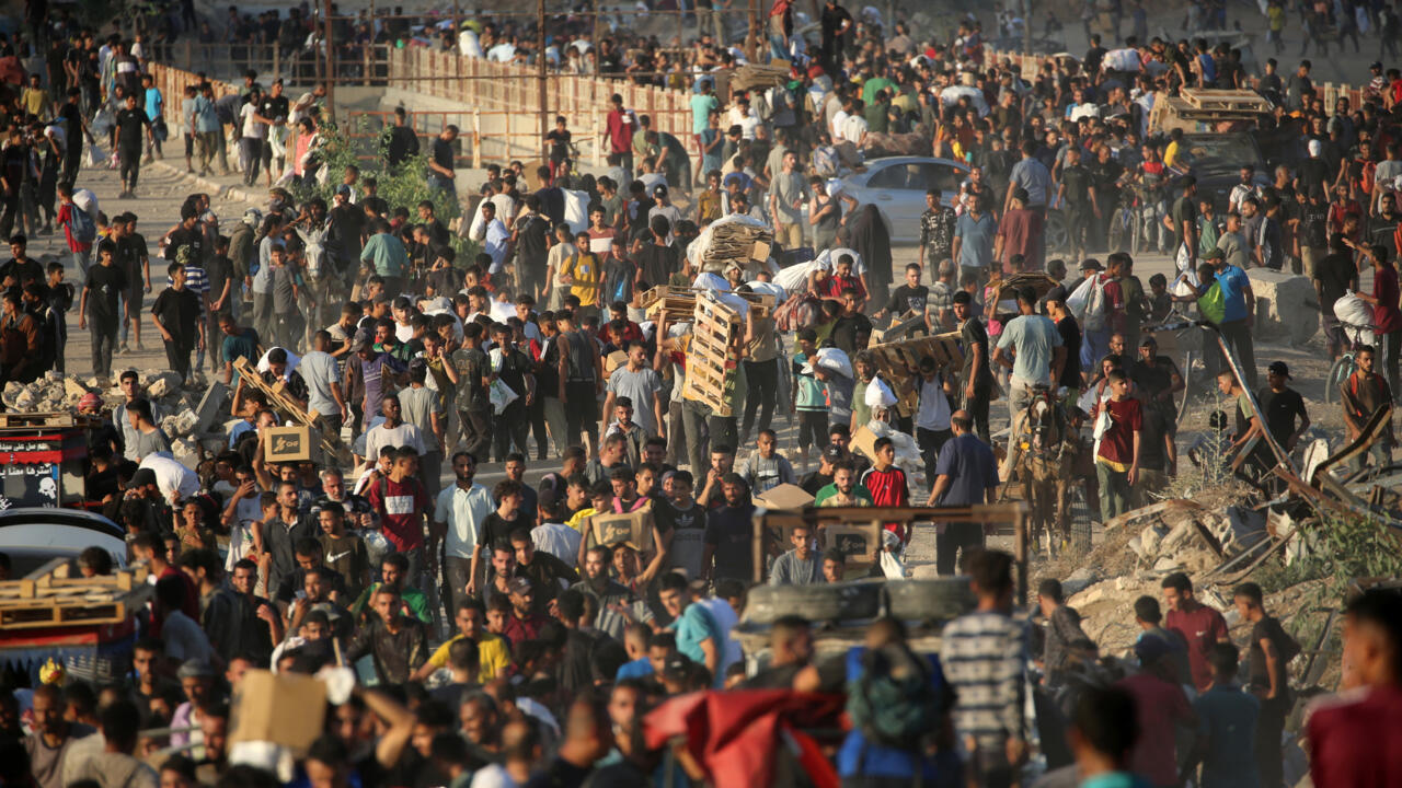 Des Palestiniens se rassemblent à un point de distribution d'aide mis en place par la Fondation humanitaire de Gaza (GHF), près du camp de réfugiés de Nuseirat, dans le centre de la bande de Gaza, le 25 juin 2025. © Eyad Baba, AFP