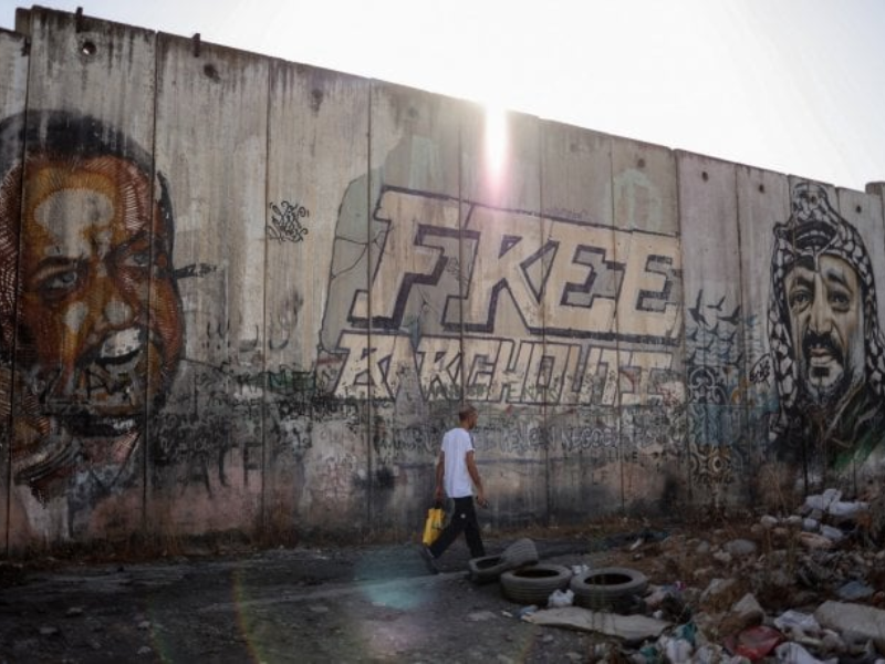 Les portraits de Marwan Barghouti (à gauche), membre éminent du Fatah et détenu palestinien le plus en vue en prison depuis un quart de siècle, et du défunt leader palestinien Yasser Arafat (à droite), qui ornent une partie du mur de séparation controversé d'Israël près du poste de contrôle de Qalandiya, entre Jérusalem et Ramallah, le 22 septembre 2025. (Photo de Zain JAAFAR / AFP)