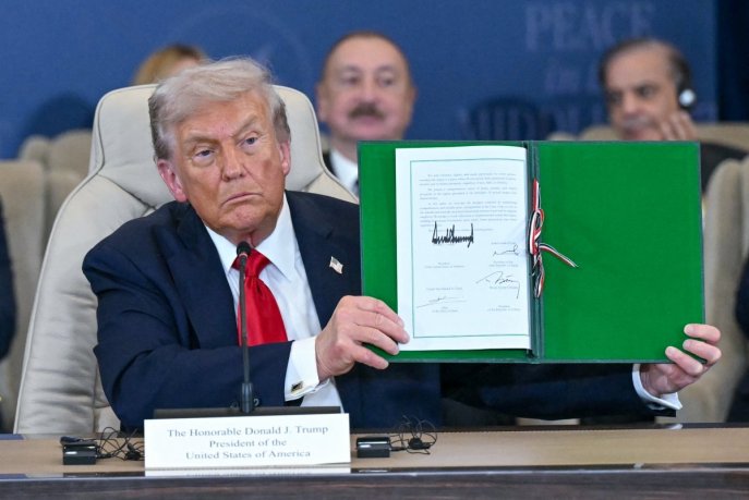 Le président américain Donald Trump montre un document signé lors du sommet sur Gaza à Charm el-Cheikh, le 13 octobre 2025. 5Photo AFP).