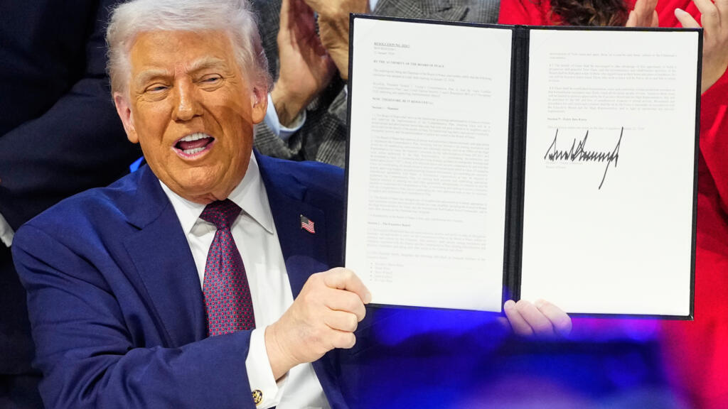 Le président américain Donald Trump tient la charte lors d'une cérémonie de signature dans le cadre de son initiative "Conseil de la paix". © Markus Schreiber, AP